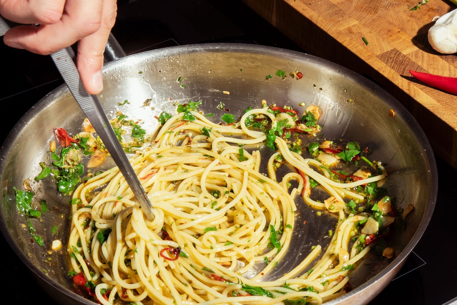 Spaghetti Aglio e Olio mit Knoblauch, Chili und Petersilie in der Pfanne